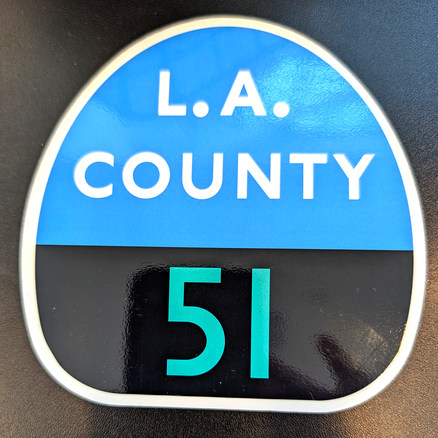Round sign with 'L.A. COUNTY 51' text on a blue and black background