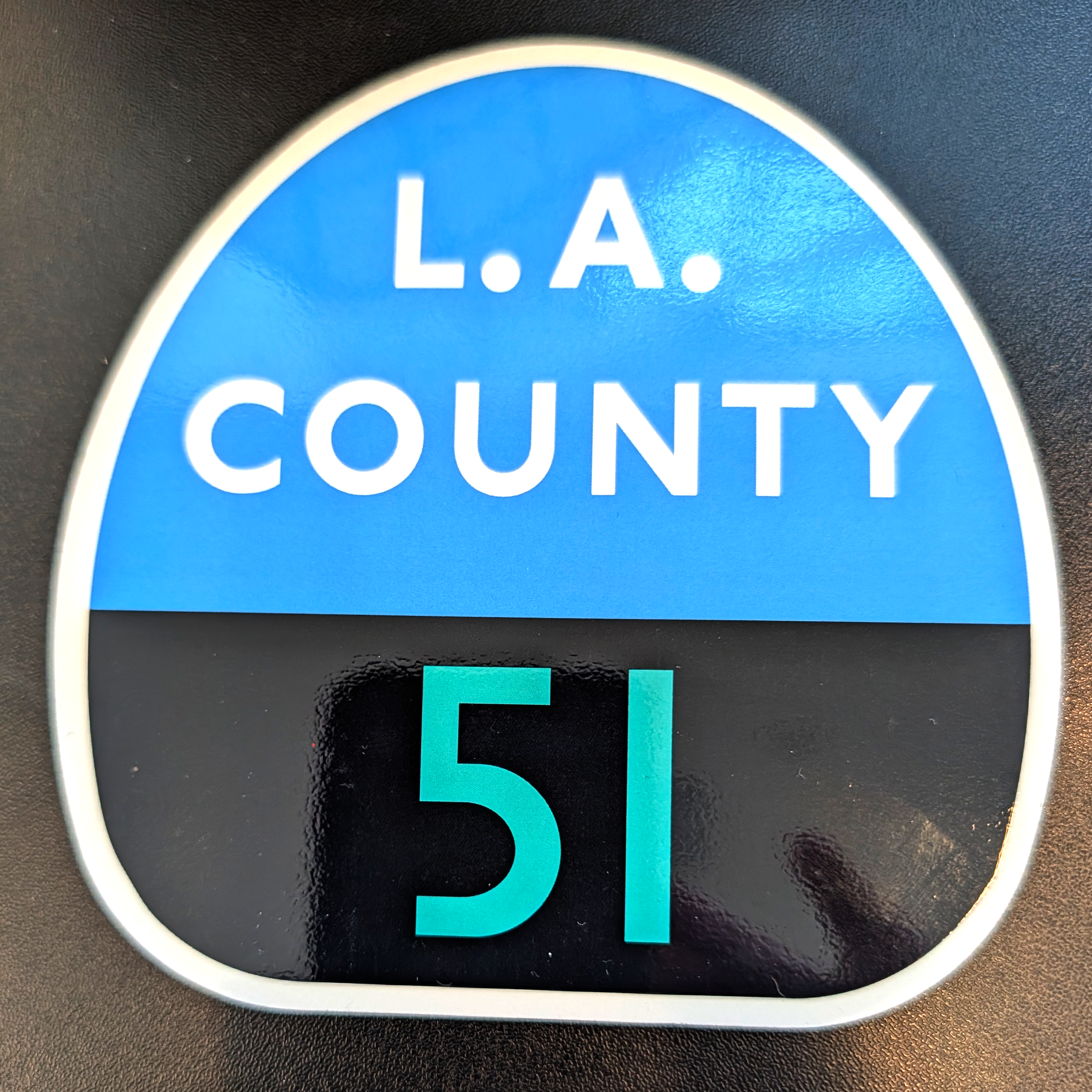 Round sign with 'L.A. COUNTY 51' text on a blue and black background