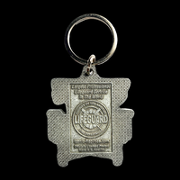 Metal keychain shaped like a life preserver with 'Largest Professional Lifeguard Service in the World County of Los Angeles Fire Department LIFEGUARD'  Lifeguard logo, then IconicReplicas.com Officially licensed product Made in N. Americaltext on a gray metal background