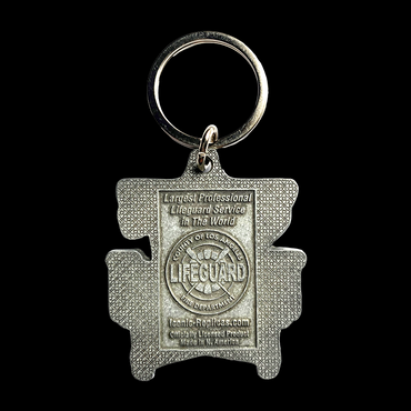 Metal keychain shaped like a life preserver with 'Largest Professional Lifeguard Service in the World County of Los Angeles Fire Department LIFEGUARD'  Lifeguard logo, then IconicReplicas.com Officially licensed product Made in N. Americaltext on a gray metal background